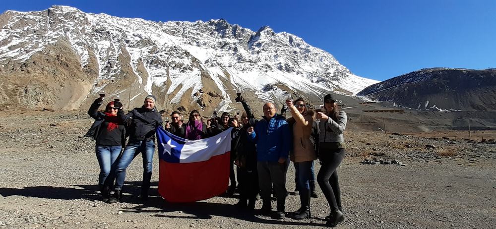 Grupo de viajeros con la bandera chilena en la Cordillera de los Andes